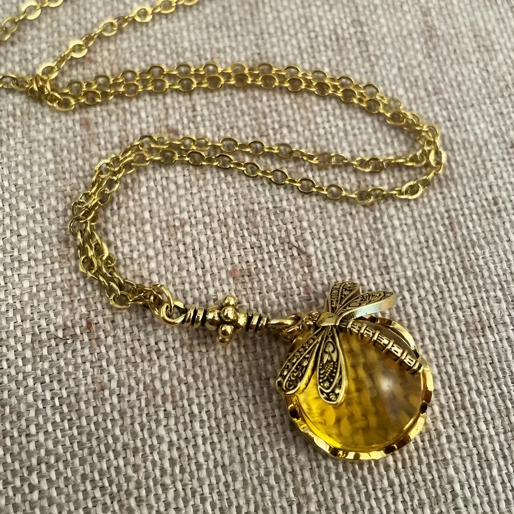 Yellow vintage bronze dragonfly pendant necklace on a silver chain, hand-carved design.