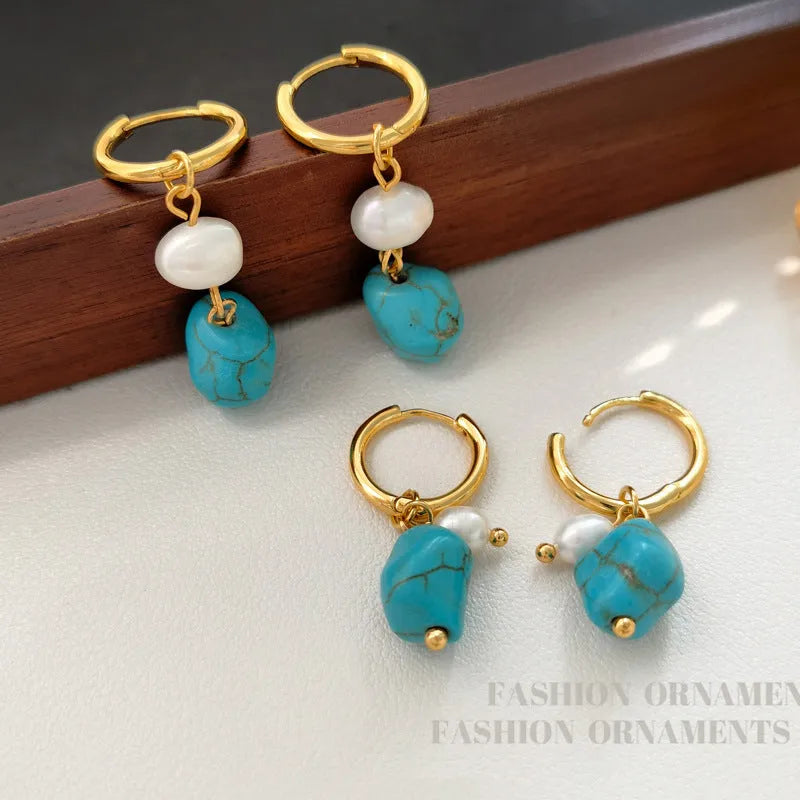 A pair of irregular shaped geometric copper ear clip earrings featuring turquoise stones and cultured pearls.