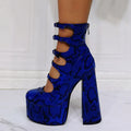 Women's black patent leather platform high heel boots with a thick heel, round toe, and serpentine ankle buckle.
