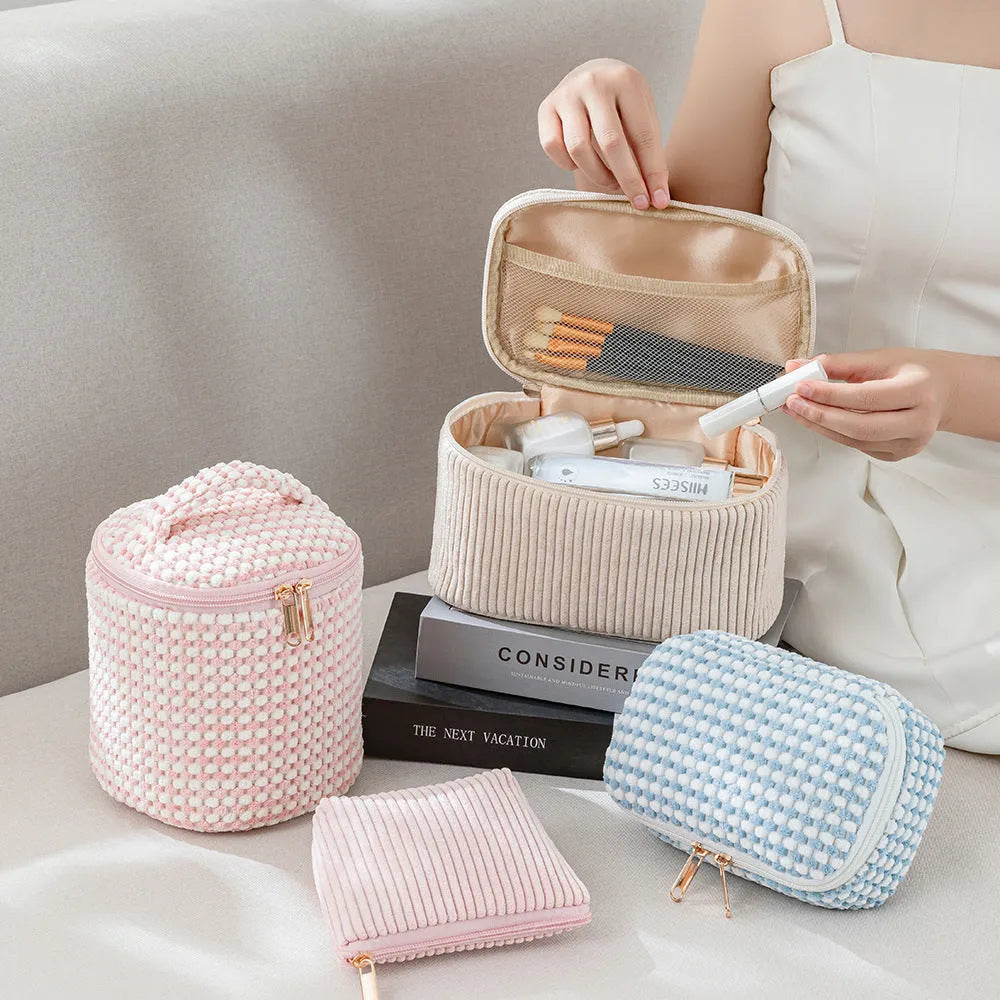 Four cube-shaped flannelette makeup bags in different colours for travel storage