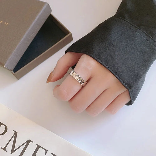 Black geometric copper ring with adjustable opening and oval design elements