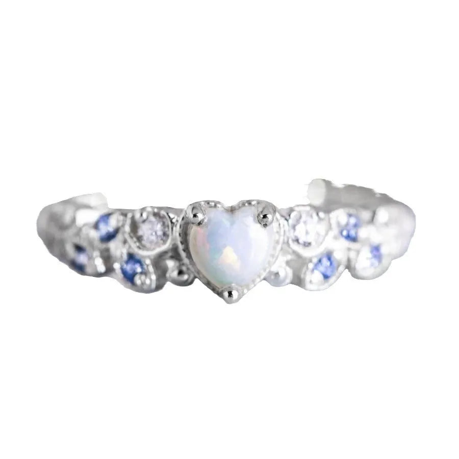 White heart-shaped women's alloy ring with floral and opal ocean design on finger