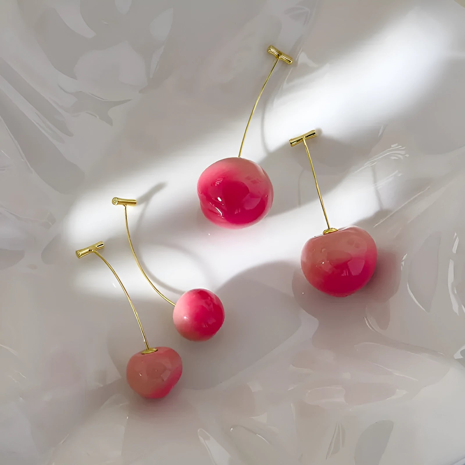 A pair of women's earrings with a clear acrylic peach charm on copper posts