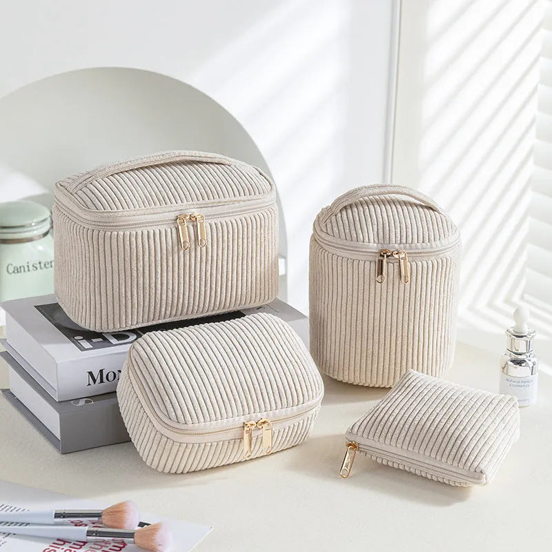 Four cube-shaped flannelette makeup bags in different colours for travel storage