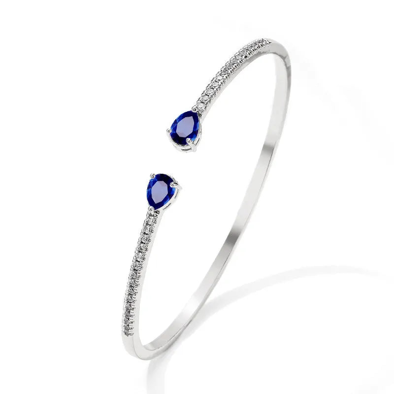 Copper fashion bracelet with inlaid white or blue zircon stones on a simple band.