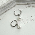 A pair of women's geometric alloy earrings with a round pearl and titanium steel posts.