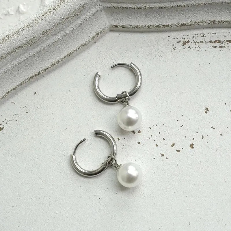 A pair of women's geometric alloy earrings with a round pearl and titanium steel posts.