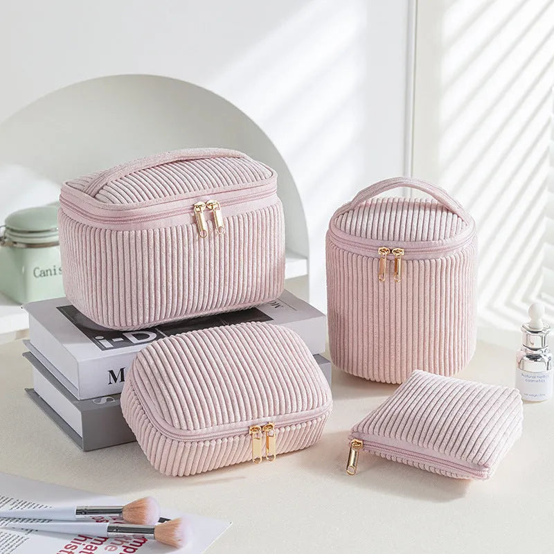 Four cube-shaped flannelette makeup bags in different colours for travel storage