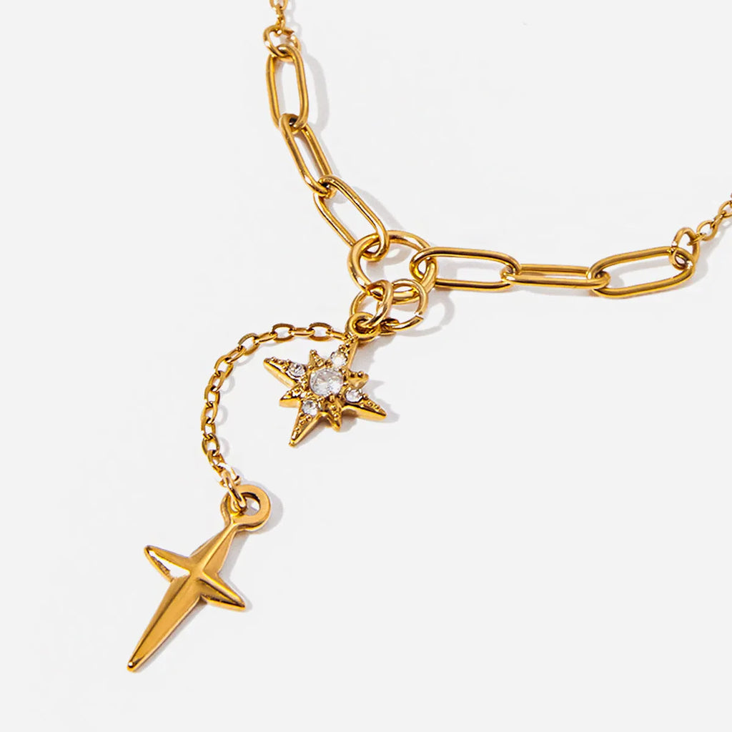 Close up of an 18K gold finish stainless steel necklace with white diamond eight-pointed stars pendant on a regular chain