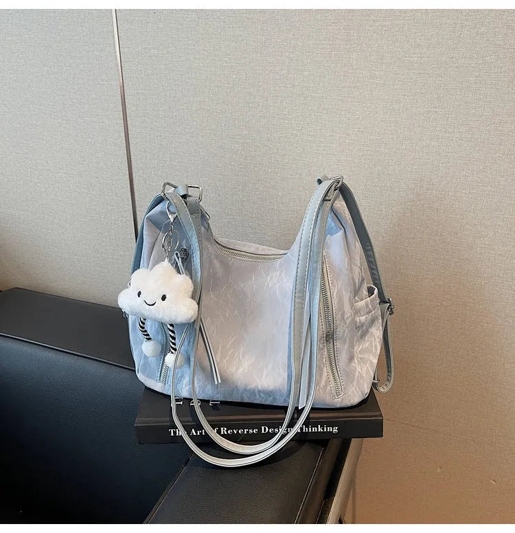 Women's soft PU fashion backpack in black, shown as a multi-functional shoulder bag with a pendant accessory.