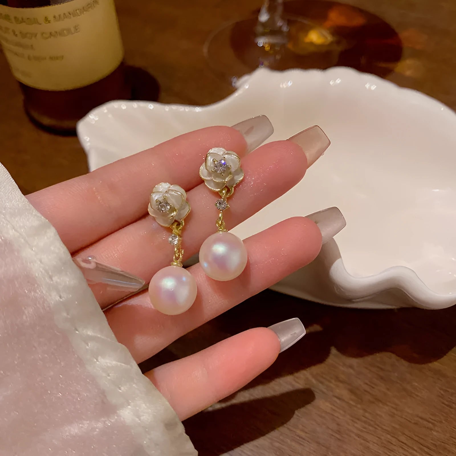 Close-up of women's camellia flower stud earrings in alloy with floral design.