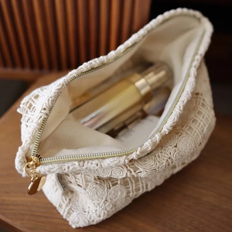 Handmade crocheted cosmetic bag with hollow floral embroidery on solid colour corduroy fabric.