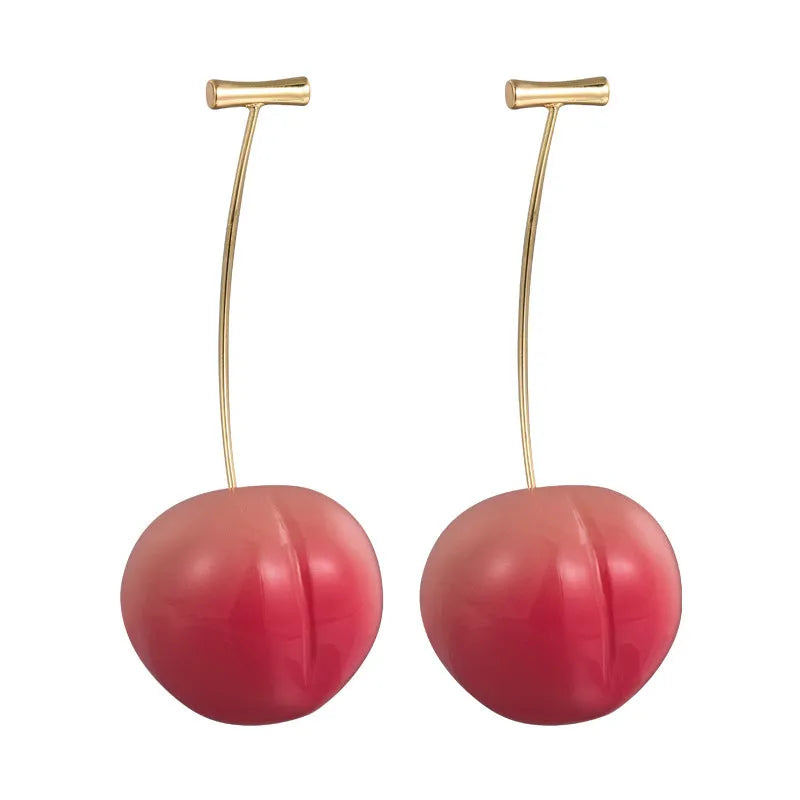 A pair of women's earrings with a clear acrylic peach charm on copper posts