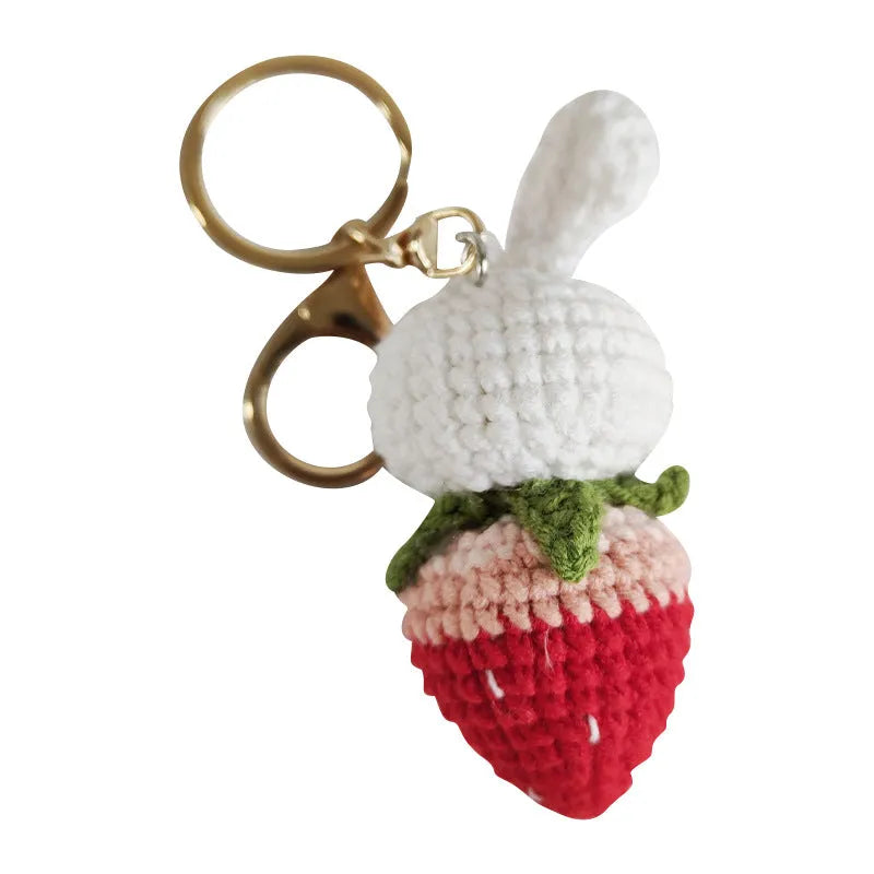 White hand-woven wire pendant with rabbit strawberry cartoon pattern and key attachment.