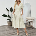Light green knee-length shirt dress with lapel collar, waist tie, and side pockets on mannequin