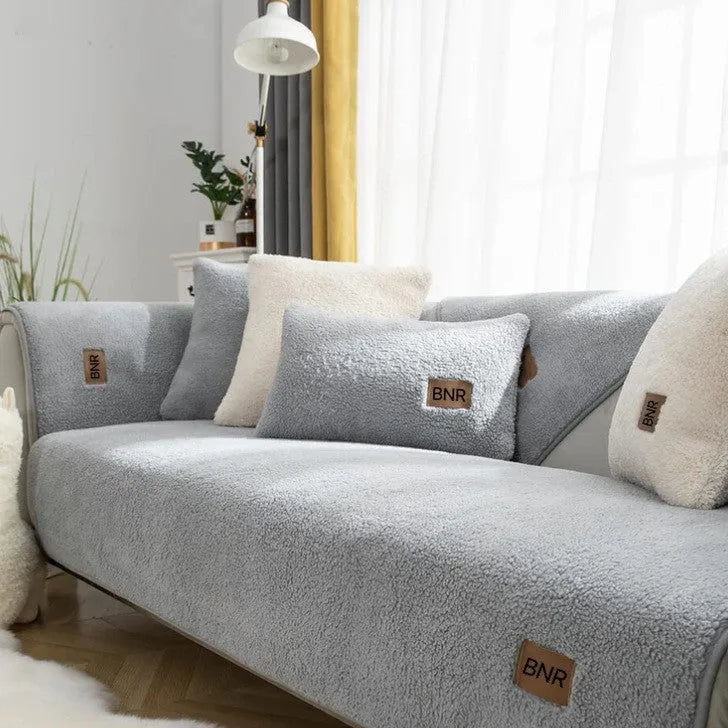 Lambswool solid colour sofa cover in blue, shown on a three-seater sofa.