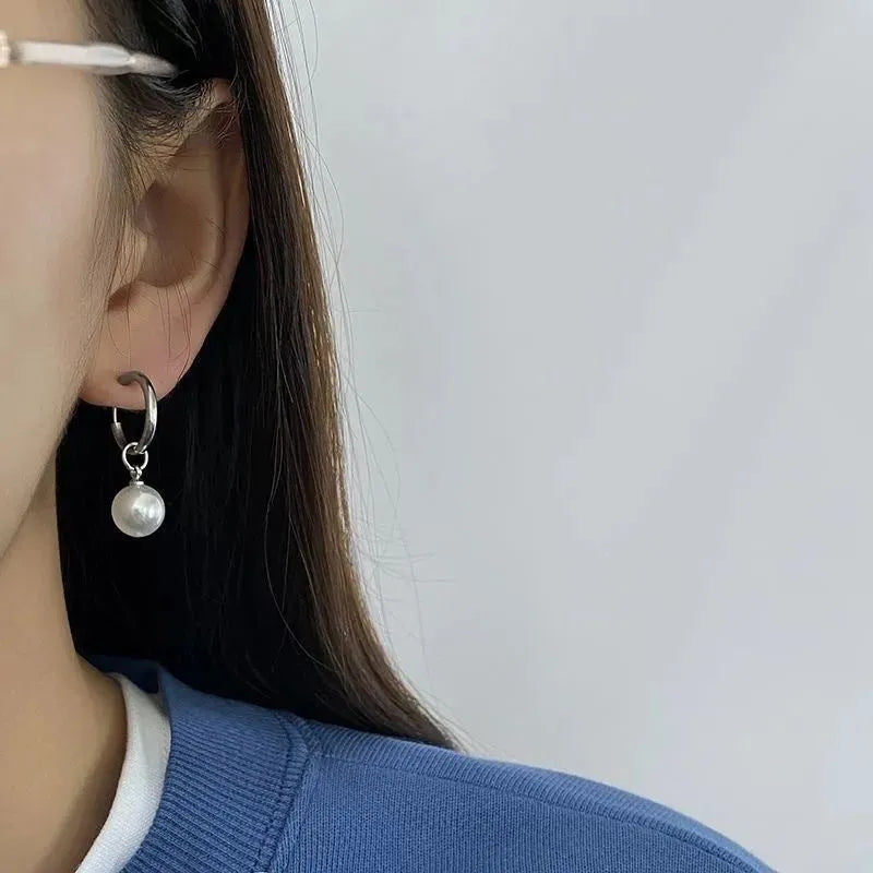 A pair of women's geometric alloy earrings with a round pearl and titanium steel posts.