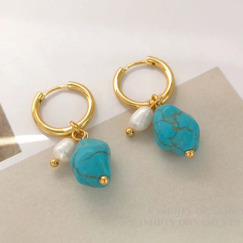A pair of irregular shaped geometric copper ear clip earrings featuring turquoise stones and cultured pearls.
