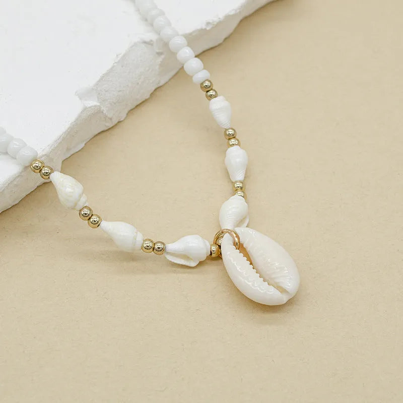 White Mother of Pearl conch shell necklace with regular chain on display