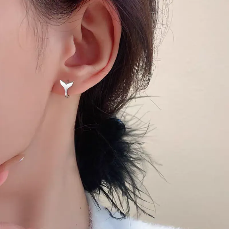 A pair of women's simple fishtail design earrings with an electroplated finish in white gold or yellow gold colour.