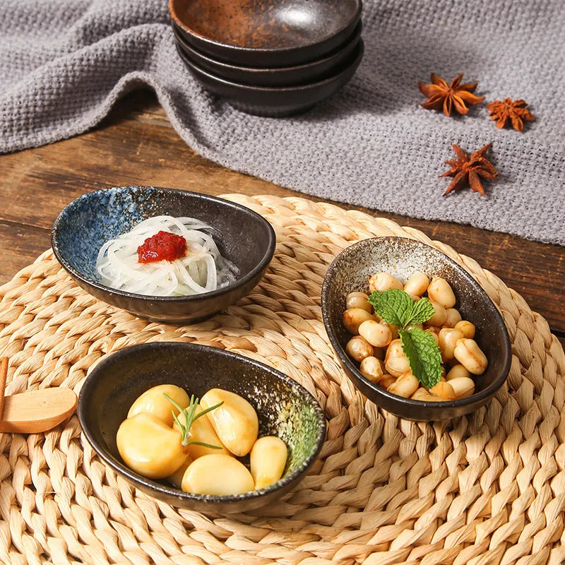 Oval Japanese ceramic sauce dipping bowl on a table, showing its 5cm height and decorative underglaze pattern.