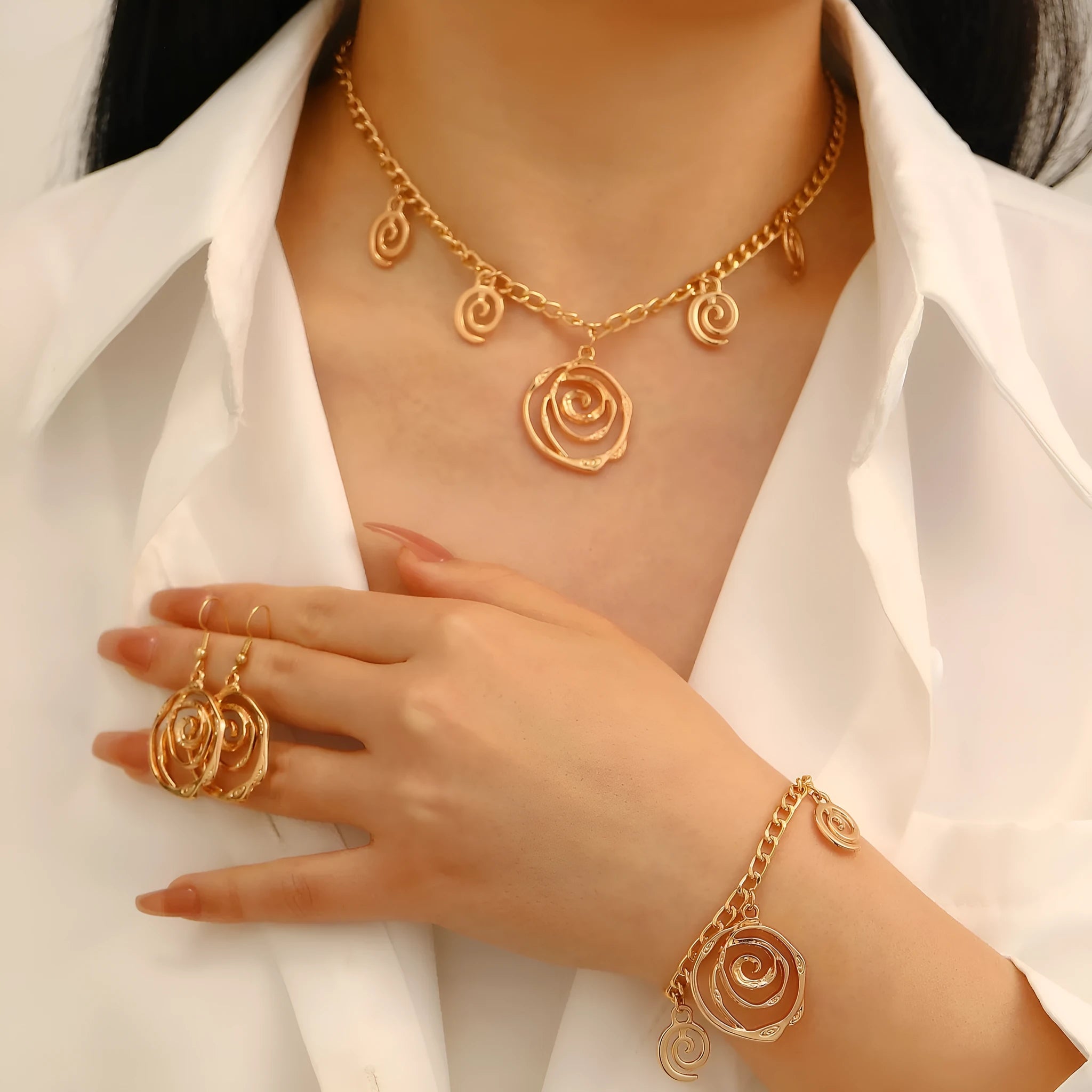 Women's spiral donut jewellery set showing matching necklace, bracelet and ear hooks in gold or silver electroplated alloy
