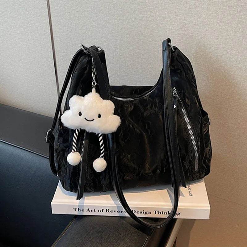 Women's soft PU fashion backpack in black, shown as a multi-functional shoulder bag with a pendant accessory.