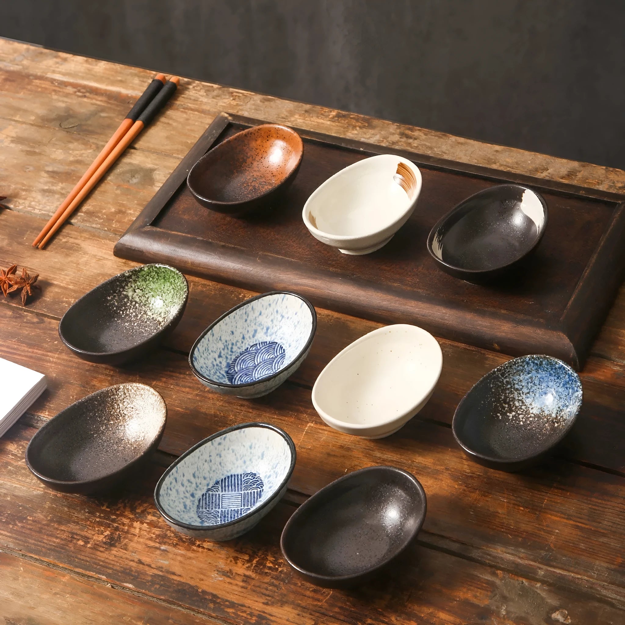 Oval Japanese ceramic sauce dipping bowl on a table, showing its 5cm height and decorative underglaze pattern.