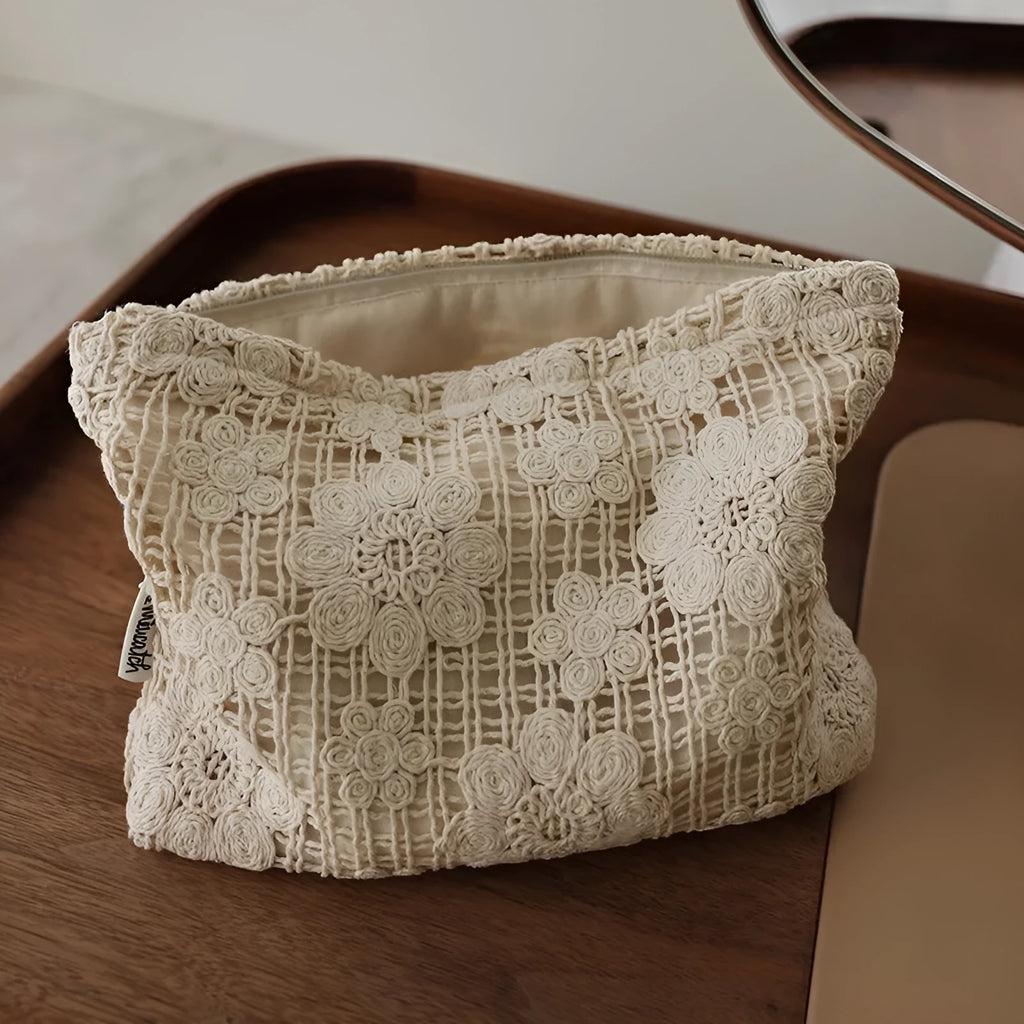 Handmade crocheted cosmetic bag with hollow floral embroidery on solid colour corduroy fabric.