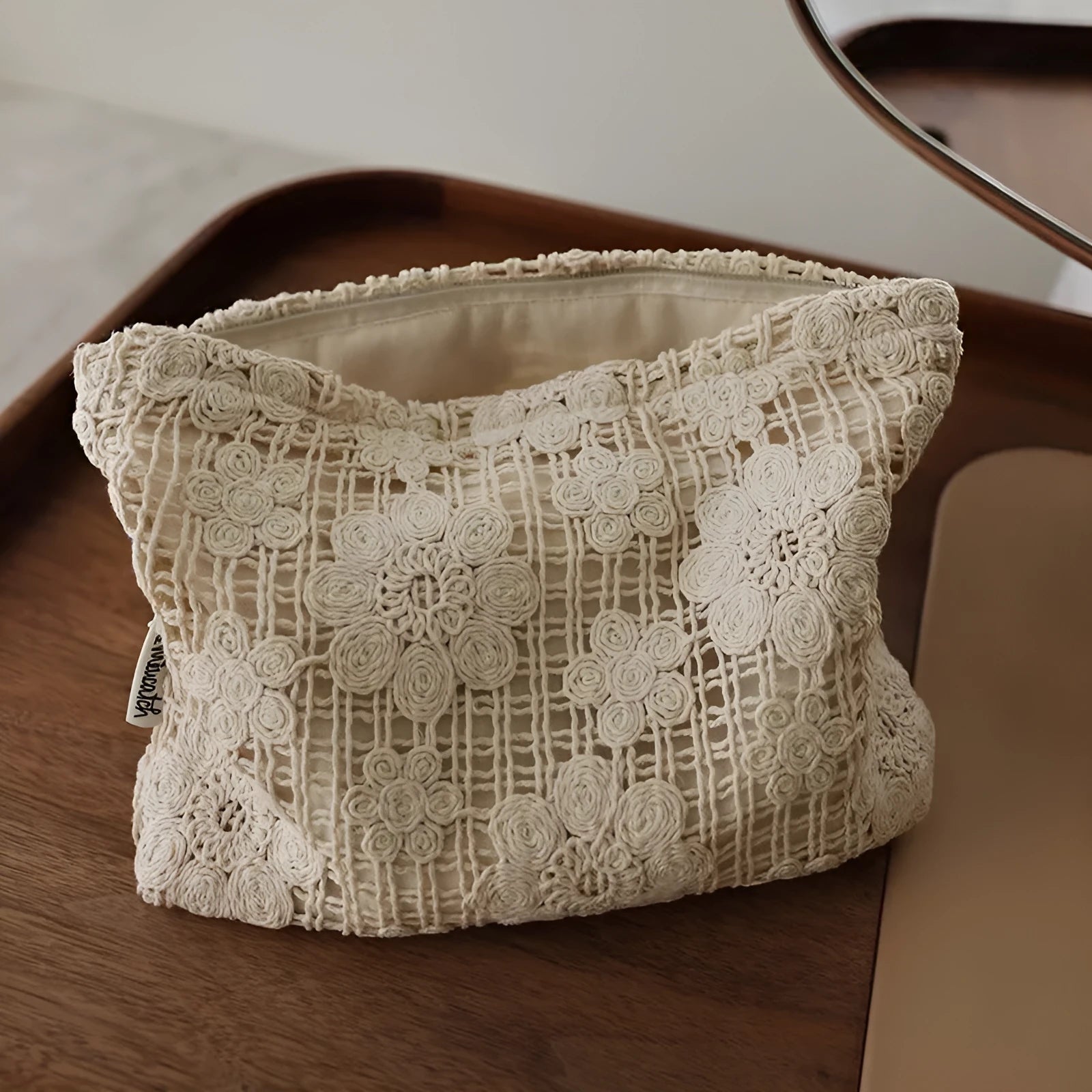 Handmade crocheted cosmetic bag with hollow floral embroidery on solid colour corduroy fabric.