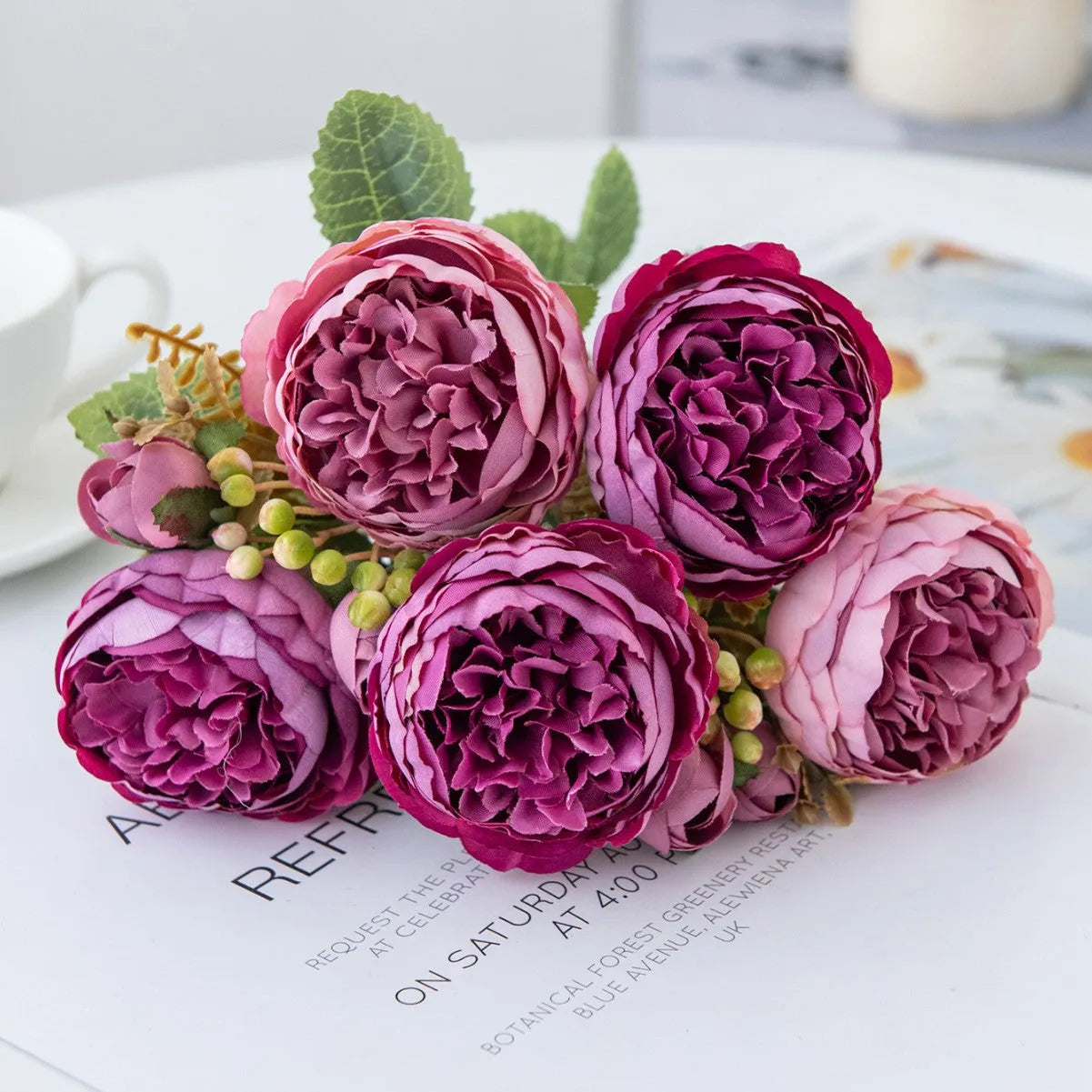 Silk artificial peony bouquet in champagne colour on a table.