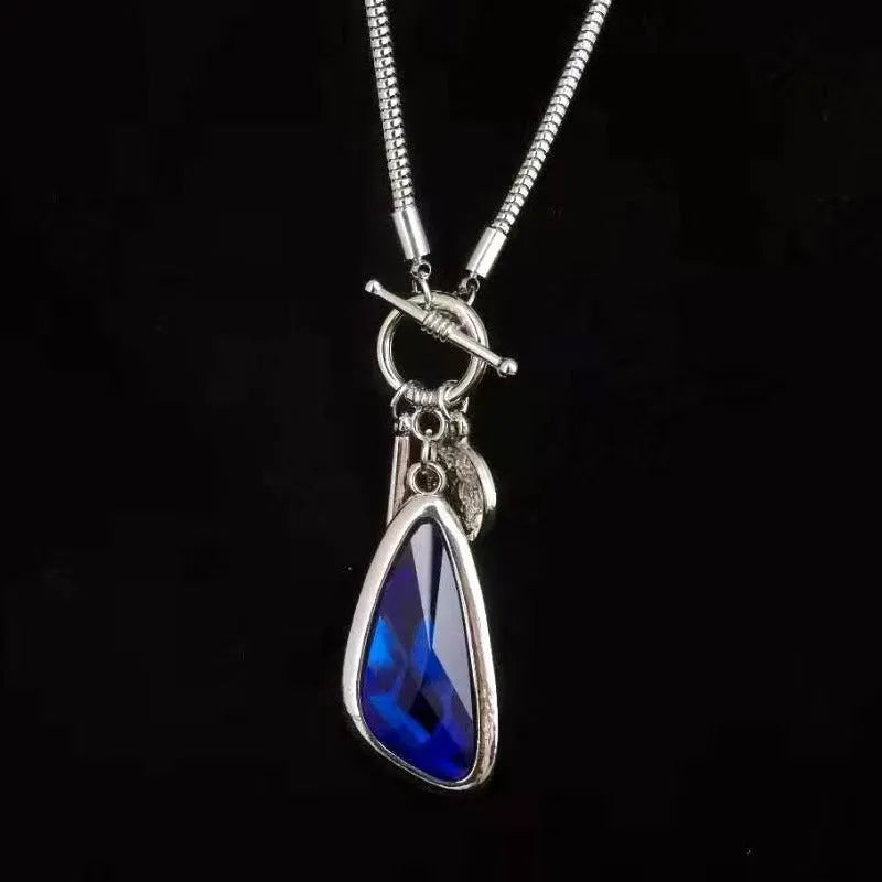 Long alloy necklace with geometric pendant on a snake bones chain, shown in blue water drop colour.