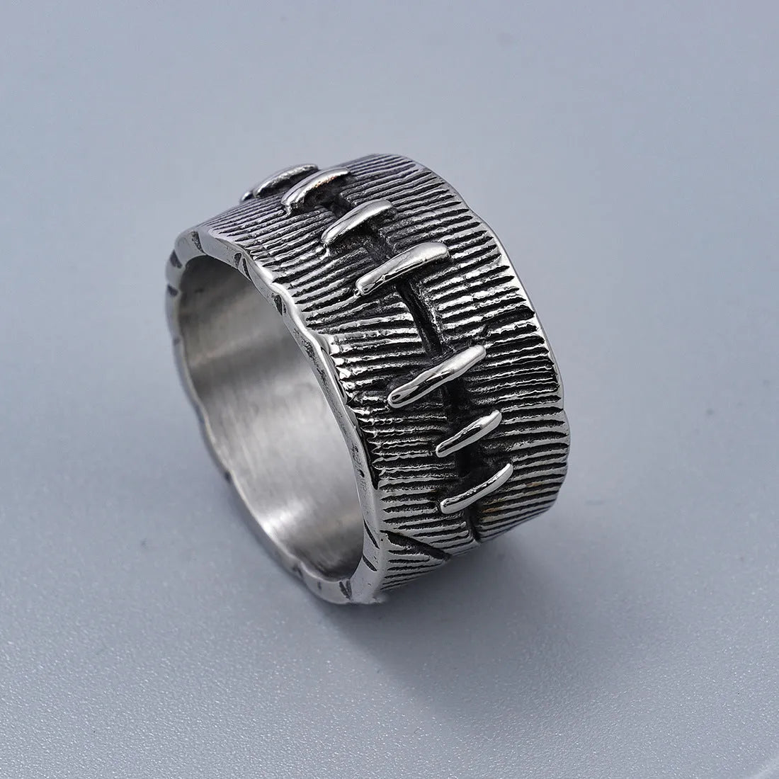 Geometric dark punk titanium steel double ring in retro colour on a black background.
