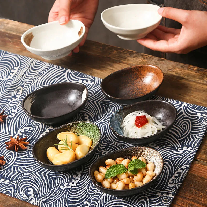 Oval Japanese ceramic sauce dipping bowl on a table, showing its 5cm height and decorative underglaze pattern.