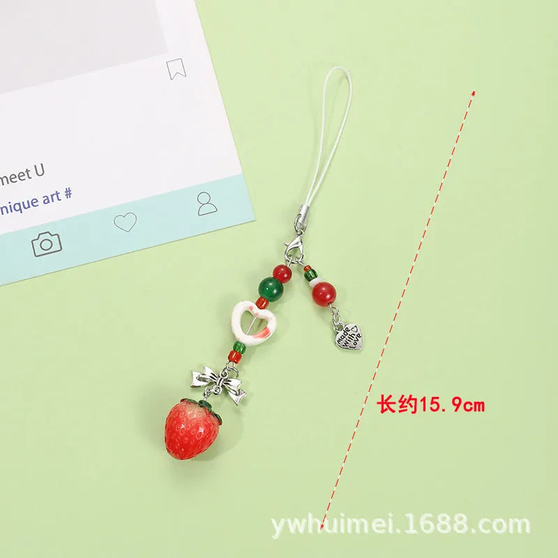 Plastic resin fruit pattern phone charm keychain pendant with apple and strawberry designs on a white rope.