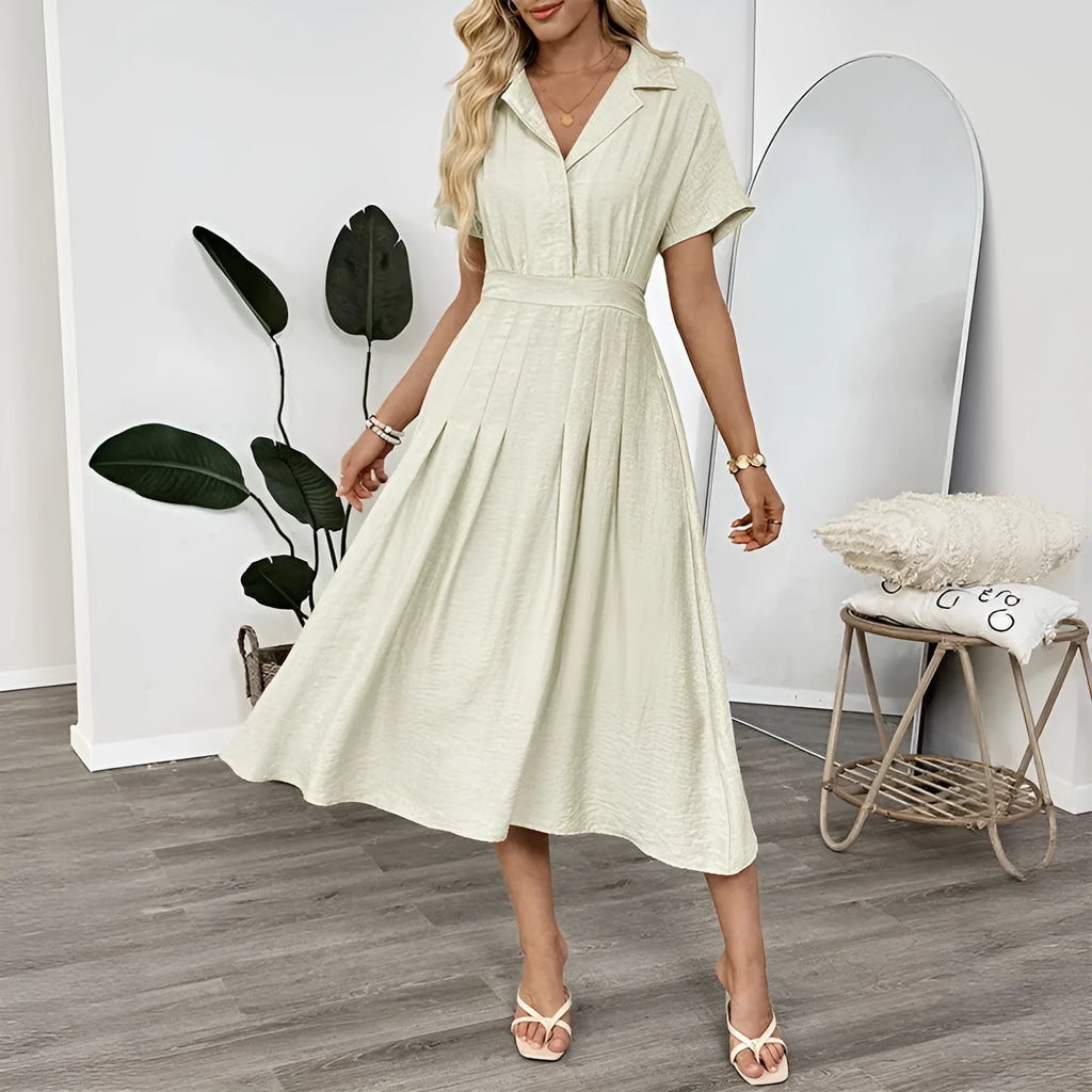 Light green knee-length shirt dress with lapel collar, waist tie, and side pockets on mannequin