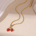 Close-up of a red stainless steel strawberry charm necklace on an alloy chain.