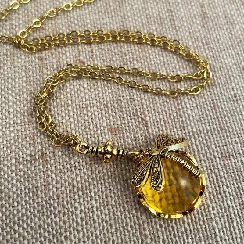 Yellow vintage bronze dragonfly pendant necklace on a silver chain, hand-carved design.