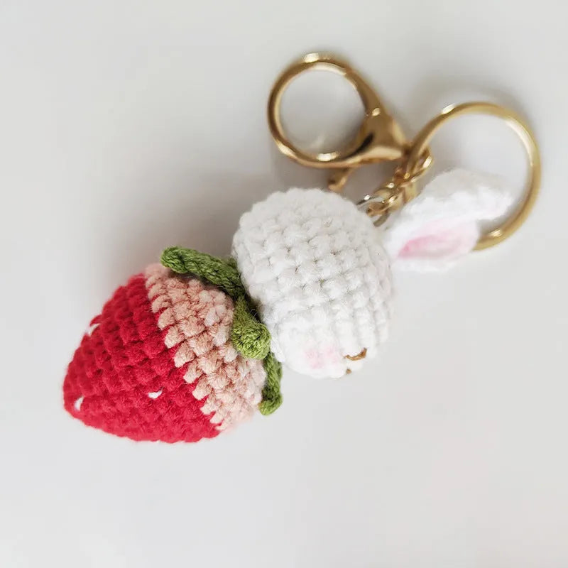 White hand-woven wire pendant with rabbit strawberry cartoon pattern and key attachment.