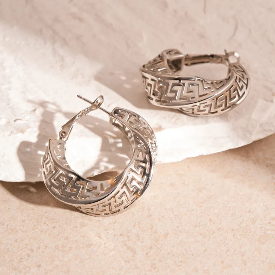 Women's twisted round geometric hollow stud earrings in silver or gold electroplated finish.