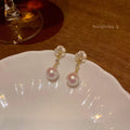 Close-up of women's camellia flower stud earrings in alloy with floral design.