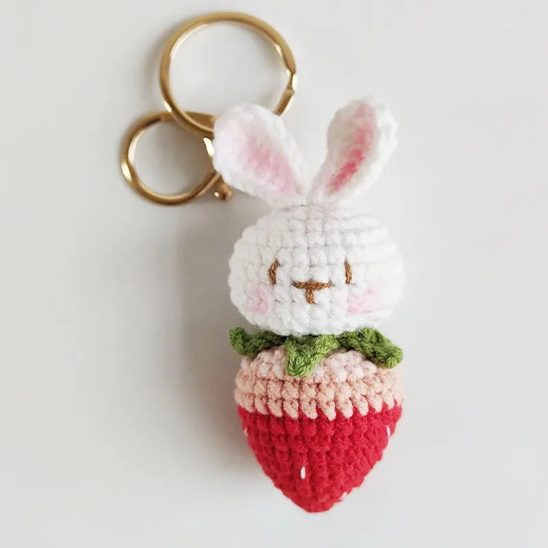 White hand-woven wire pendant with rabbit strawberry cartoon pattern and key attachment.