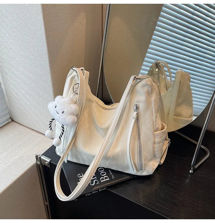 Women's soft PU fashion backpack in black, shown as a multi-functional shoulder bag with a pendant accessory.
