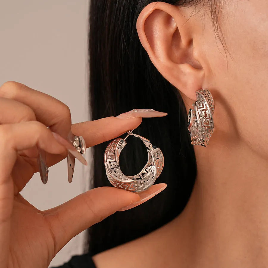 Women's twisted round geometric hollow stud earrings in silver or gold electroplated finish.