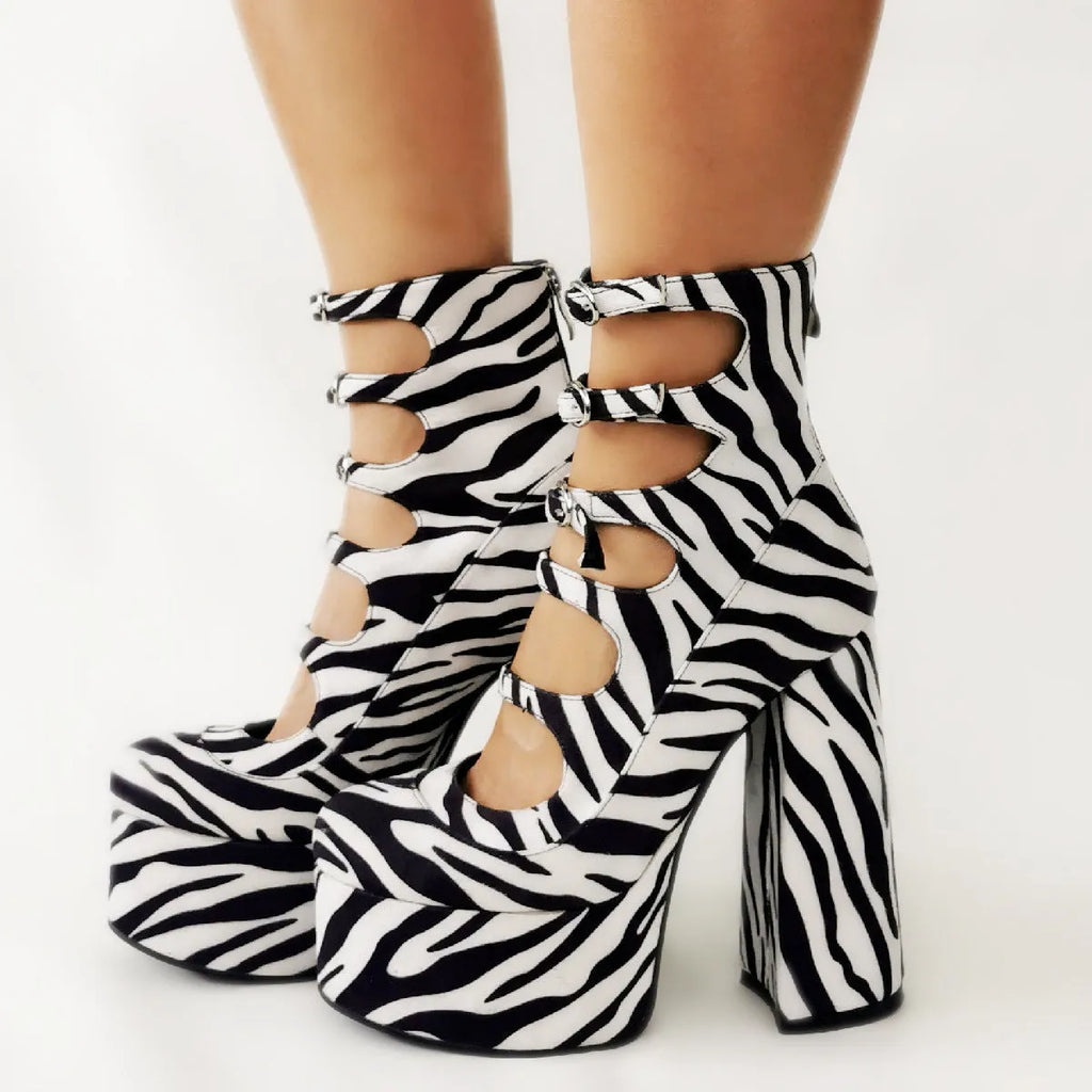 Women's black patent leather platform high heel boots with a thick heel, round toe, and serpentine ankle buckle.