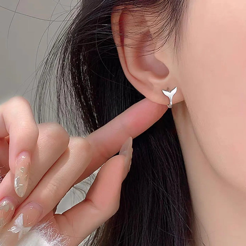A pair of women's simple fishtail design earrings with an electroplated finish in white gold or yellow gold colour.