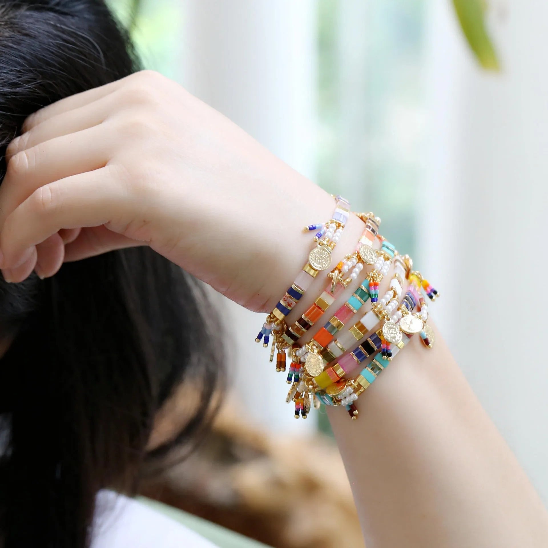 Women's imitation pearl and glass beaded bracelet showing six different colour variations with adjustable closure