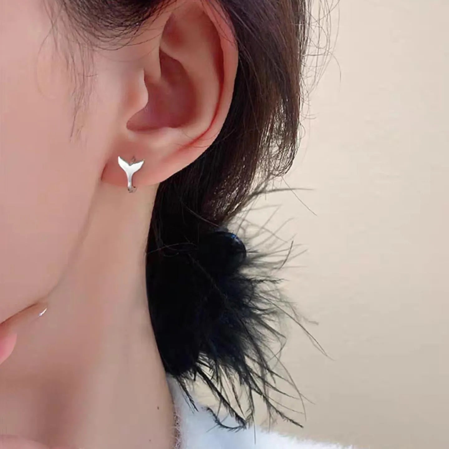 A pair of women's simple fishtail design earrings with an electroplated finish in white gold or yellow gold colour.
