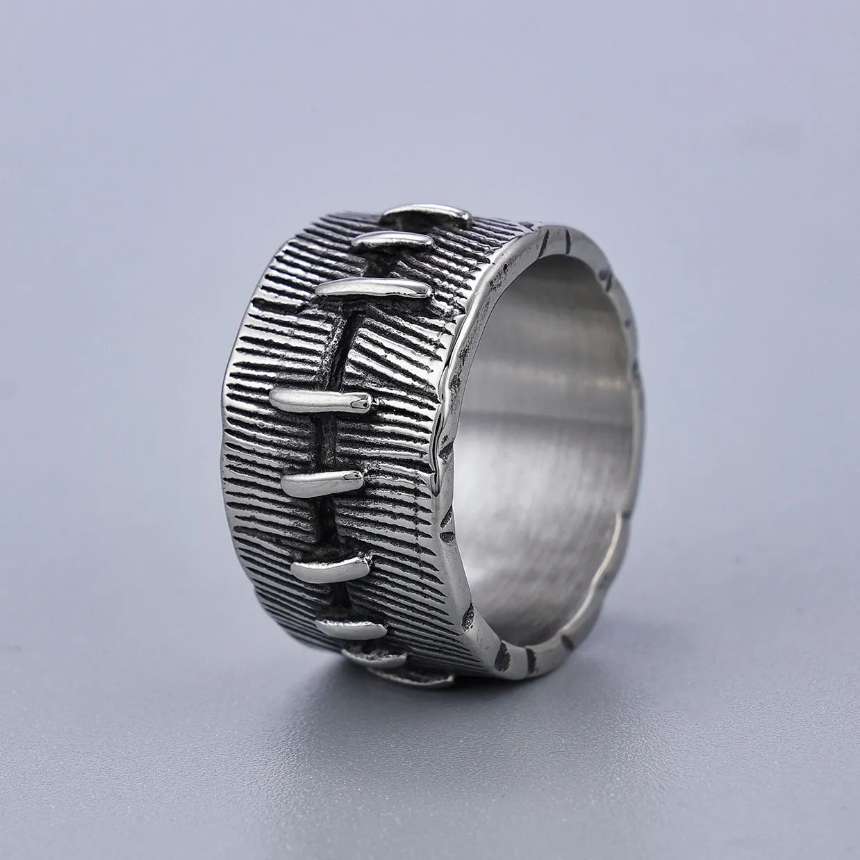 Geometric dark punk titanium steel double ring in retro colour on a black background.