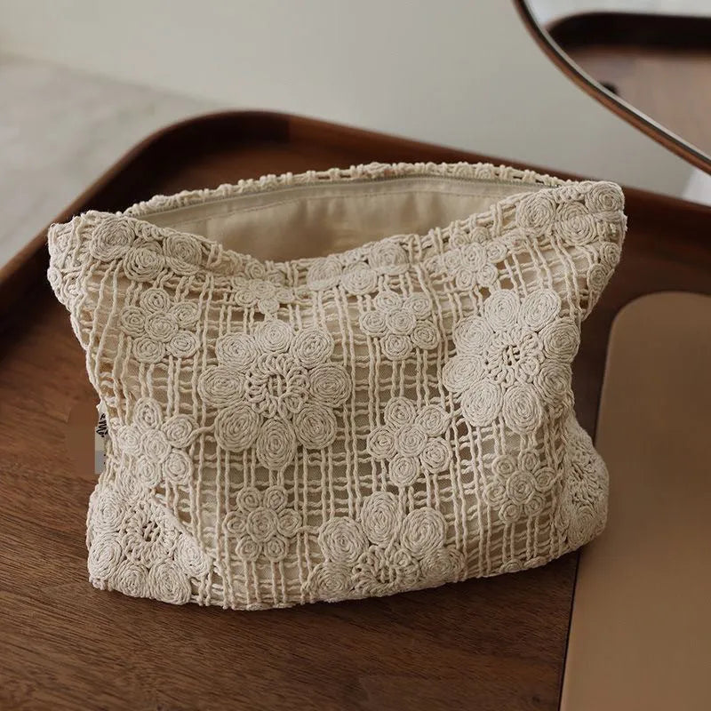Handmade crocheted cosmetic bag with hollow floral embroidery on solid colour corduroy fabric.